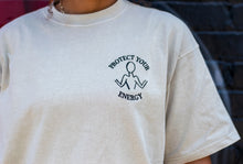 Load image into Gallery viewer, CLOSE UP OF PROTECT YOUR ENERGY LOGO IN THE LIGHT SAND OVERSIZED SHIRT
